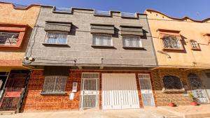 un ancien bâtiment en briques avec une porte et des fenêtres blanches dans l'établissement dar haut de gamme Et à un prix imaginaire Hostcom, à Oujda