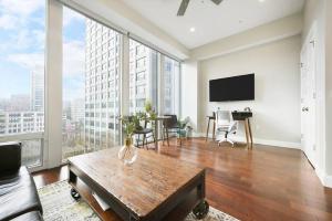 a living room with a table and a large window at HostWise Stays - The Washington at Chatham - Free Parking, Private Gym, City Views! in Pittsburgh