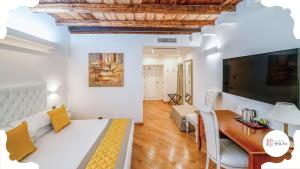 Camera con letto, scrivania e TV. di Maison Spagna Suites a Roma