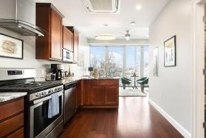 a kitchen with wooden cabinets and a stove top oven at HostWise Stays - The Washington at Chatham - Free Parking, Private Gym, Skyline Views! in Pittsburgh