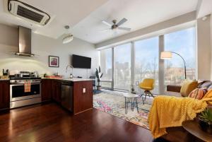 a kitchen and living room with a large window at HostWise Stays - The Washington at Chatham - Free Parking, Private Gym, Skyline Views! in Pittsburgh