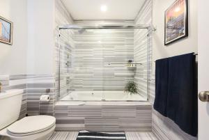 een badkamer met een douche, een toilet en een bad bij HostWise Stays - The Washington at Chatham - Free Parking, Fitness Center in Pittsburgh