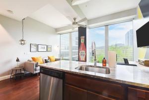 a kitchen with a sink and a living room at HostWise Stays - The Washington at Chatham - Free Parking, Fitness Center in Pittsburgh