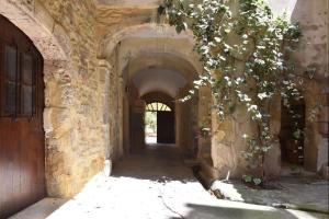 an alley with an archway in a stone building at La caverne de la rose d'or in Orange