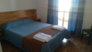 a bedroom with a bed with two towels on it at Sol Pampa in Concordia