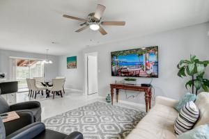 a living room with a couch and a ceiling fan at Just Remodeled! Close to All! 3 Miles to Beach!! 2 Miles From Airport! in West Palm Beach