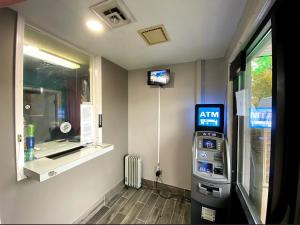 a gas station with a atm machine next to a window at DELUXE INN in Erie