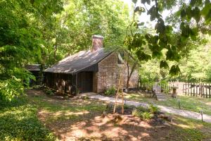 an old brick house in the middle of a yard at Rose Hill Inn in Versailles