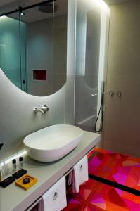 een badkamer met een witte wastafel en een spiegel bij ZOE LUXURY SUITES in Catania