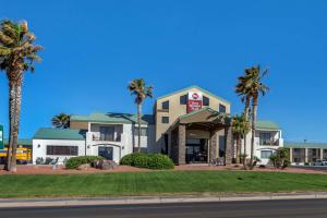 a hotel with palm trees in front of a street at Best Western Plus King's Inn and Suites in Kingman