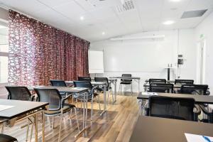 ein leeres Klassenzimmer mit Tischen, Stühlen und einem roten Vorhang in der Unterkunft Best Western Hotell Ljungby in Ljungby