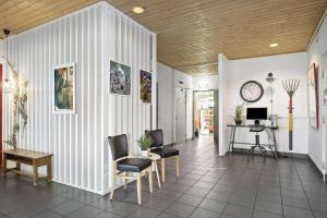 a living room with a table and chairs and a clock at Sure Hotel by Best Western Lagan in Lagan