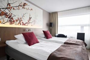 a hotel room with two beds with red pillows at Best Western Hotell Ljungby in Ljungby