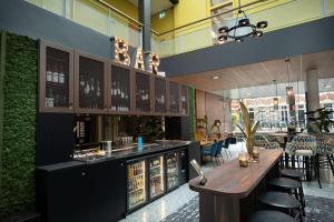 un restaurante con un bar con mesas y sillas en Flonk Hotel Groningen Centre, BW Signature Collection en Groninga