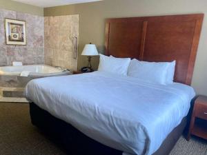 a hotel room with a large bed and a bath tub at Best Western Emporia Inn in Emporia