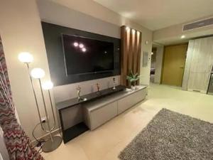 a living room with a large television and a living roomarijavascript at Lovely 2-bedroom apartment with pool view in Hurghada