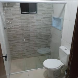 a bathroom with a toilet and a glass shower at Residencial Dona Preta in Florianópolis