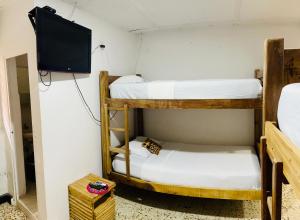 Pokój z 2 łóżkami piętrowymi i telewizorem z płaskim ekranem w obiekcie Hostal Liwa Kashi w mieście Ríohacha