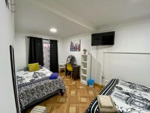 Zimmer mit 2 Betten und einem Schreibtisch. in der Unterkunft Hostal Familiar S&G in Santiago