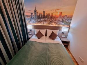 a bedroom with a bed with a view of a city at Sophien Hotel in Frankfurt/Main