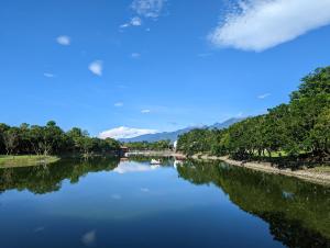 um rio com árvores e um céu azul em Ramble Travel Homestay em Guanshan