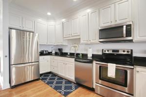 a kitchen with white cabinets and stainless steel appliances at Anchors Away in Myrtle Beach