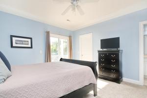 a bedroom with a bed and a dresser with a television at Anchors Away in Myrtle Beach