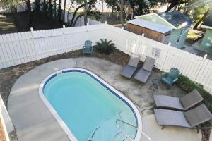 a swimming pool with chairs and a fence at Anchors Away in Myrtle Beach