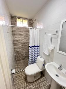 Baño blanco con aseo y lavamanos en Yellow House en Quimbaya