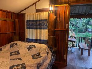 a bedroom with a bed in a room with a porch at บ้านสวนวิวทุ่ง in Ban Mae Sap Nua