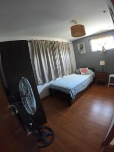 1 dormitorio con 1 cama y ventilador. en Casa Santa Ana Miramar Buenos Aires en Miramar