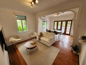 a living room with a couch and a table at Classic Brisbane Queenslander with Pool & Yard in Brisbane