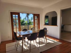 a dining room with a table and chairs at Classic Brisbane Queenslander with Pool & Yard in Brisbane