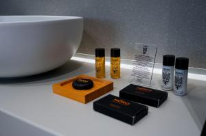 a white counter with three bottles ofotherapyamineshibahibahibahibahibahibahiba at ZOE LUXURY SUITES in Catania +63 photos