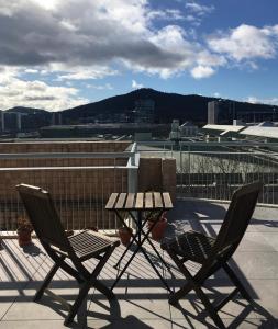 2 chaises et une table de pique-nique sur le toit dans l'établissement Private room with ensuite in the CBD, à Canberra