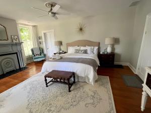 a bedroom with a large bed and a fireplace at Rose Hill Inn in Versailles