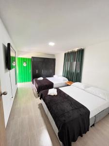 pokój hotelowy z 2 łóżkami i telewizorem z płaskim ekranem w obiekcie Yellow House w mieście Quimbaya