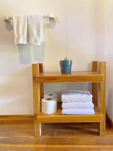 a wooden towel rack with towels on a shelf at Casa Colores in Montezuma