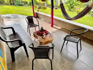 een patio met 4 stoelen, een tafel en een raam bij Yellow House in Quimbaya