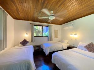 a bedroom with two beds and a ceiling fan at Casa Colores in Montezuma