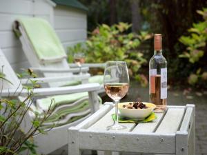 a glass of wine and a bowl of food on a table at Gierle Garden Bungalow Escape in Lille +33 photos