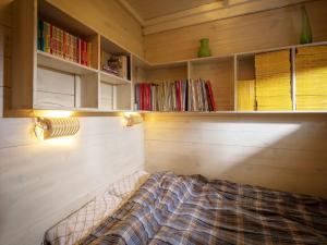 a room with a bed and shelves with books at Tranquil bungalow in Lille with garden in Lille