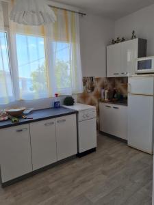 una cucina con armadi bianchi e piano di lavoro blu di Apartments by the sea Sveti Petar, Biograd - 6168 a Sveti Petar