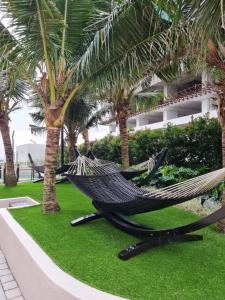 eine Hängematte in einem Resort mit Palmen in der Unterkunft Sea view Bali Residence Melaka in Malakka