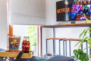 a room with a tv and two bottles of soda at Flats Una's Corner - Novos - Ar Condicionado in Barra do Una