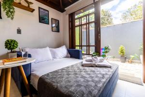 a bedroom with a bed and a table and a window at Flats Una's Corner - Novos - Ar Condicionado in Barra do Una