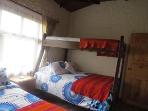 1 dormitorio con 2 literas y ventana en Rancho Santa Inés Completo, en Monguí