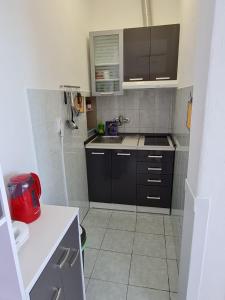 małą kuchnię z czarnymi szafkami i zlewem w obiekcie Apartments by the sea Sveti Petar, Biograd - 6167 w mieście Sveti Filip i Jakov