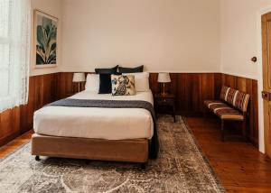- une chambre avec un grand lit et une chaise dans l'établissement Stanley Hotel & Apartments, à Stanley