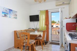 cocina y comedor con mesa y sillas en Apartments by the sea Businci, Ciovo - 9450, en Trogir